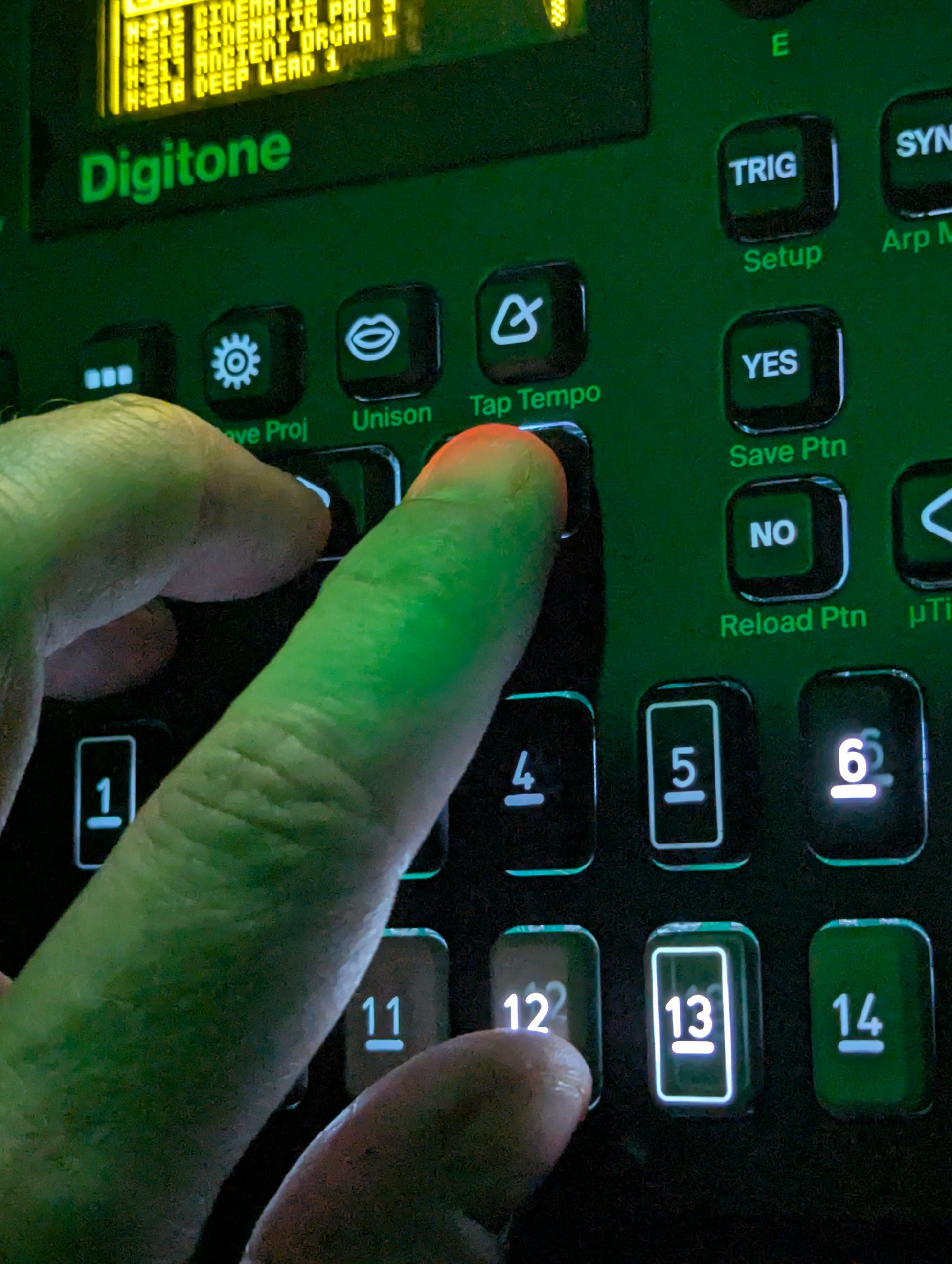 Fingers pressing illuminated buttons in Digitone synthesizer